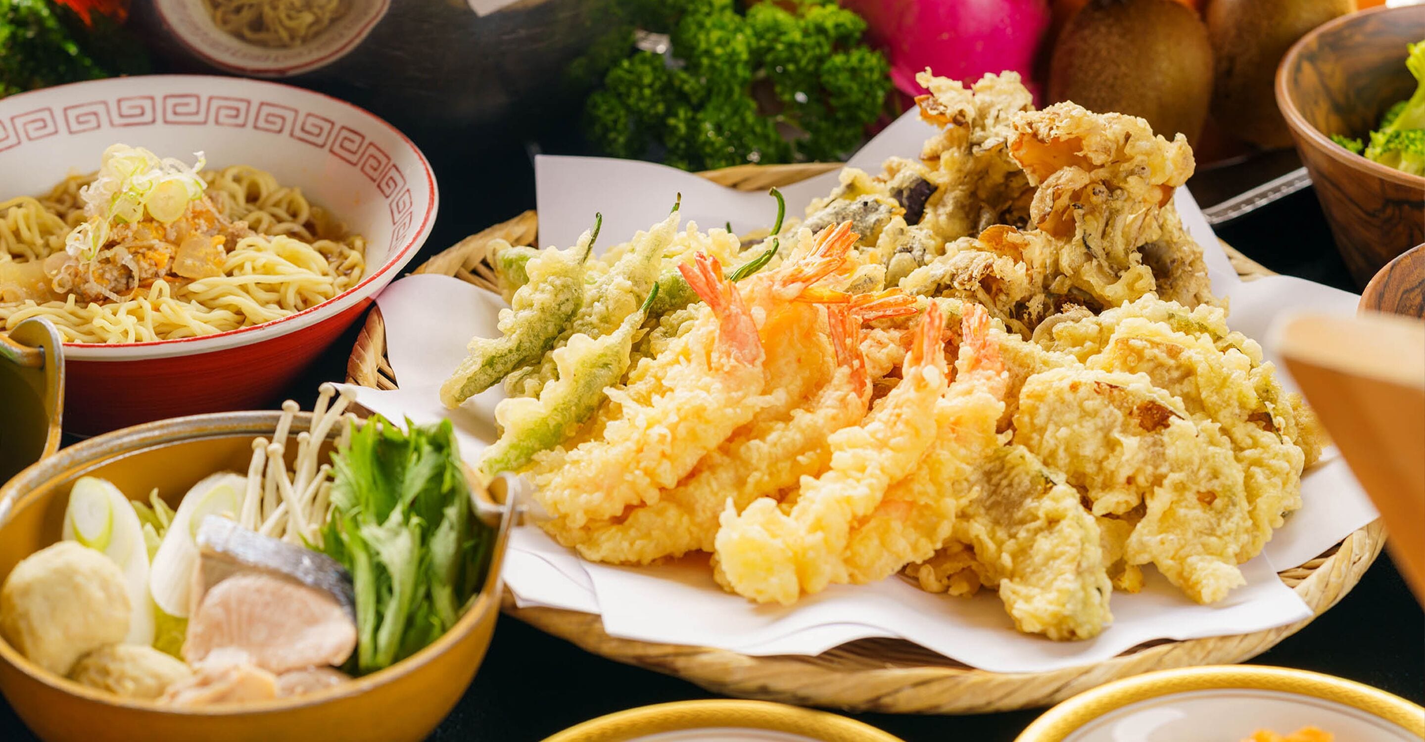 A variety of dishes including noodles, fried items, and vegetables.
