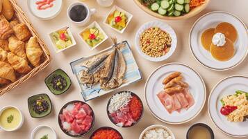 A variety of dishes including fish, sashimi, and rice bowls, arranged on a wooden table.