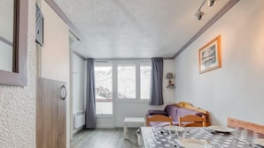 Ein gemütliches Zimmer mit einem Bett, einem kleinen Tisch und einem Fenster mit Vorhängen.