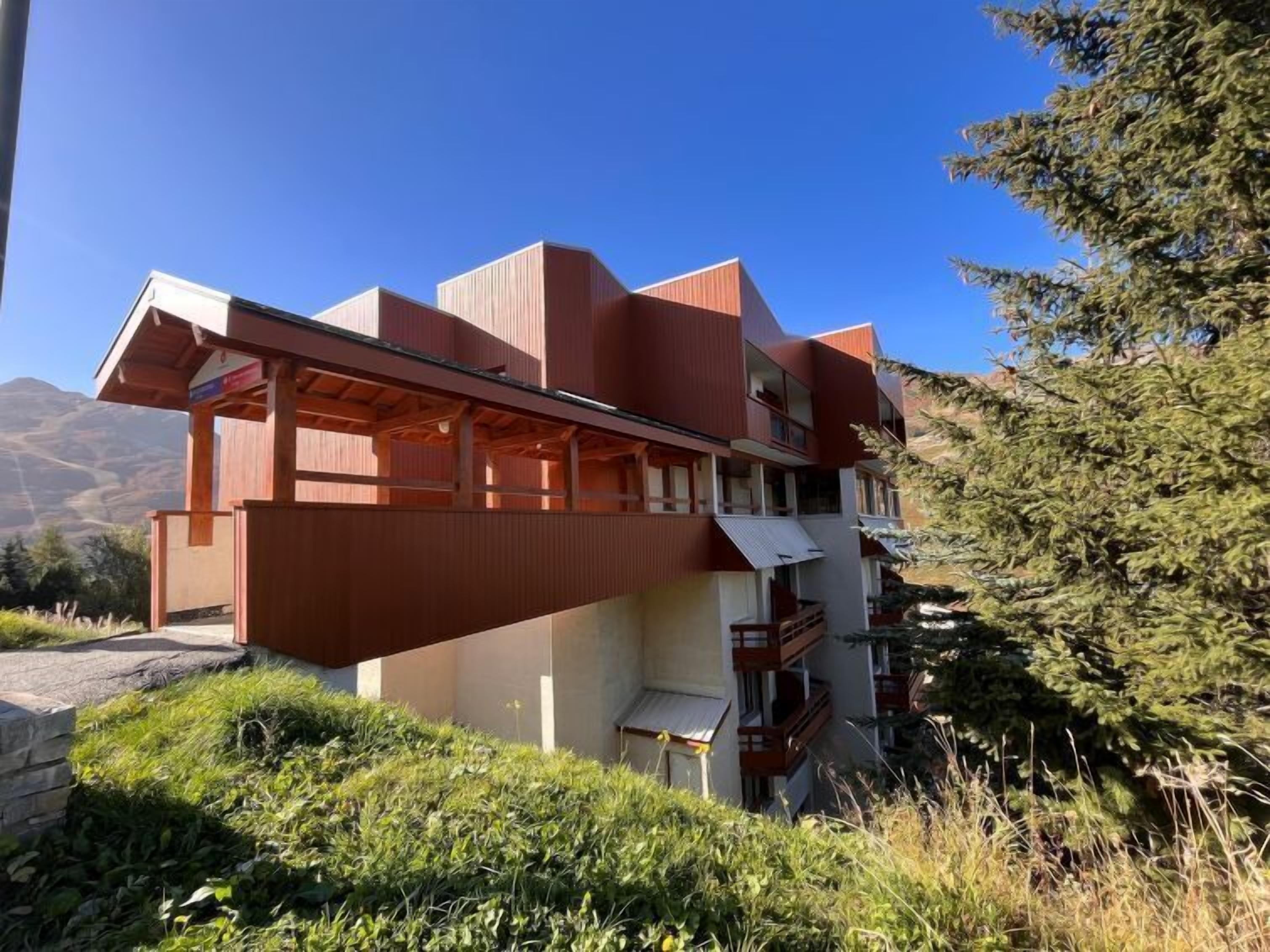 Un edificio moderno con techo inclinado y balcón.