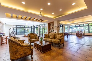 A spacious living area with a large sofa set, a coffee table, and a dining table with chairs. - Jimei Rustic Homestay (Ji'an)
