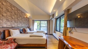 A hotel room with a brick wall, two beds, a wooden desk, a TV, and a window with curtains. - Jimei Rustic Homestay (Ji'an)
