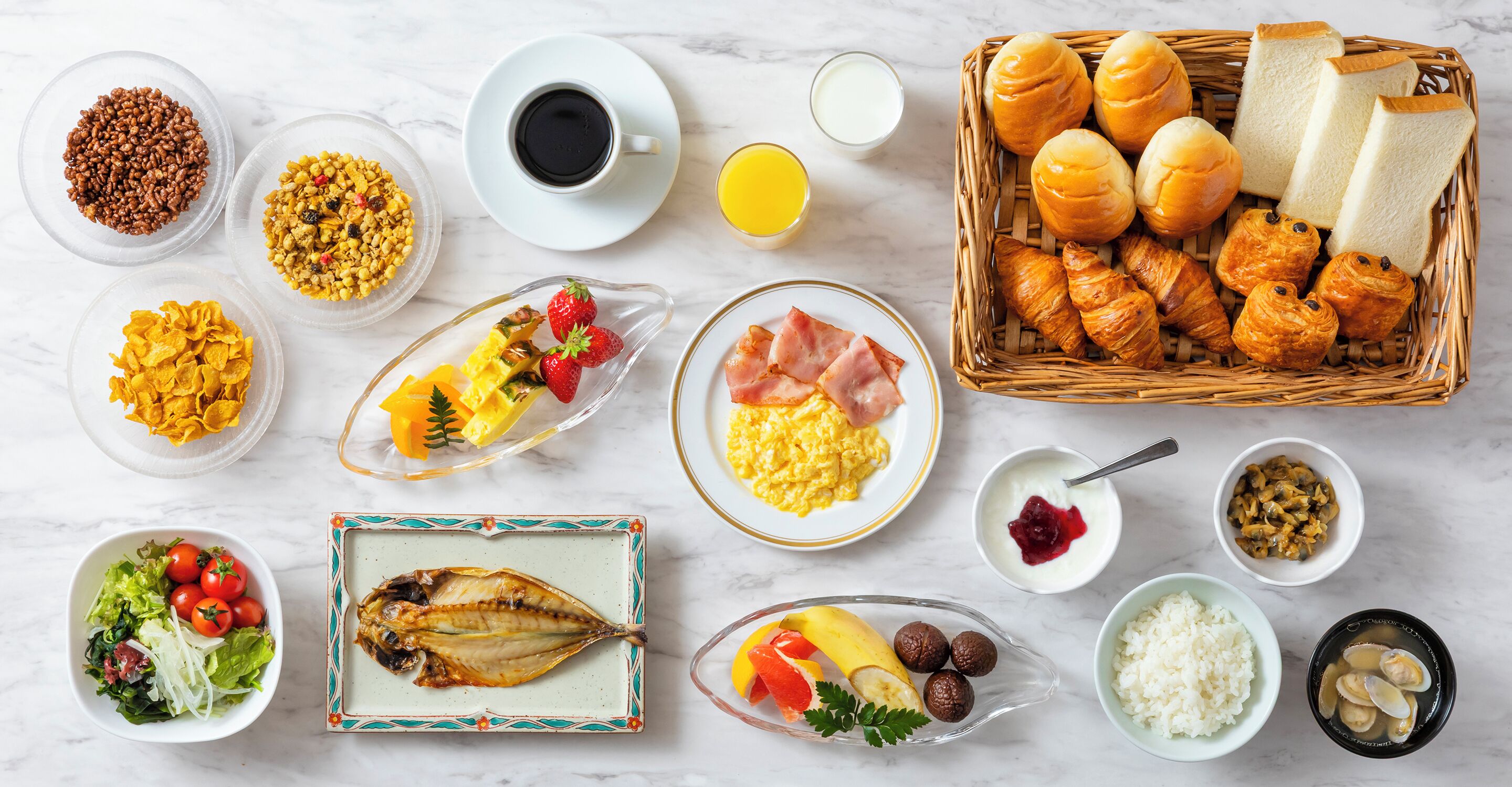 A variety of breakfast foods including cereal, eggs, bread, and fruits.