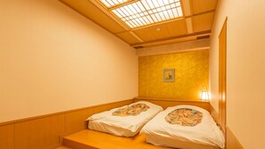 A room with two beds, a skylight, a wall-mounted picture, and a small table with a lamp. - Mikazuki Sea-Park Hotel Awa Kamogawa (Kamogawa)