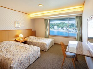 A hotel room with two beds, a desk, and a view of the sea. - Mikazuki Sea-Park Hotel Awa Kamogawa (Kamogawa)
