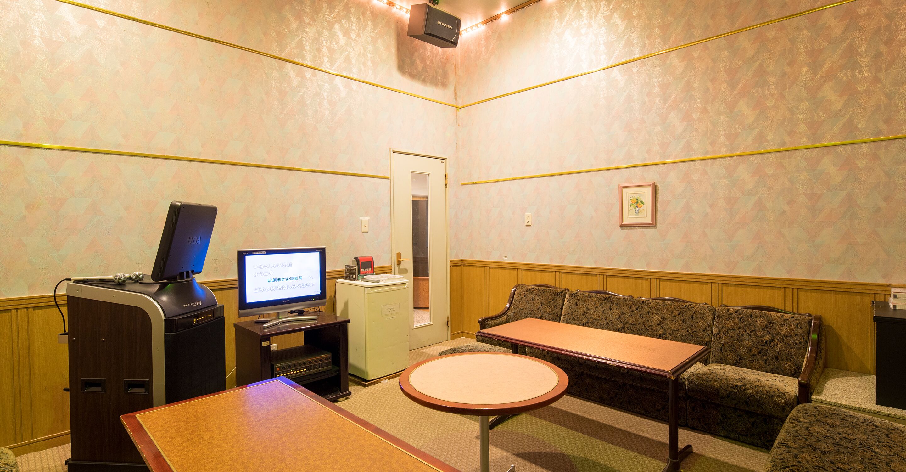 A small, private room with a desk, a computer, a sofa, and a small table.