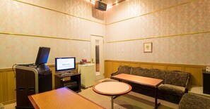 A small, private room with a desk, a computer, a sofa, and a small table. - Mikazuki Sea-Park Hotel Awa Kamogawa (Kamogawa)