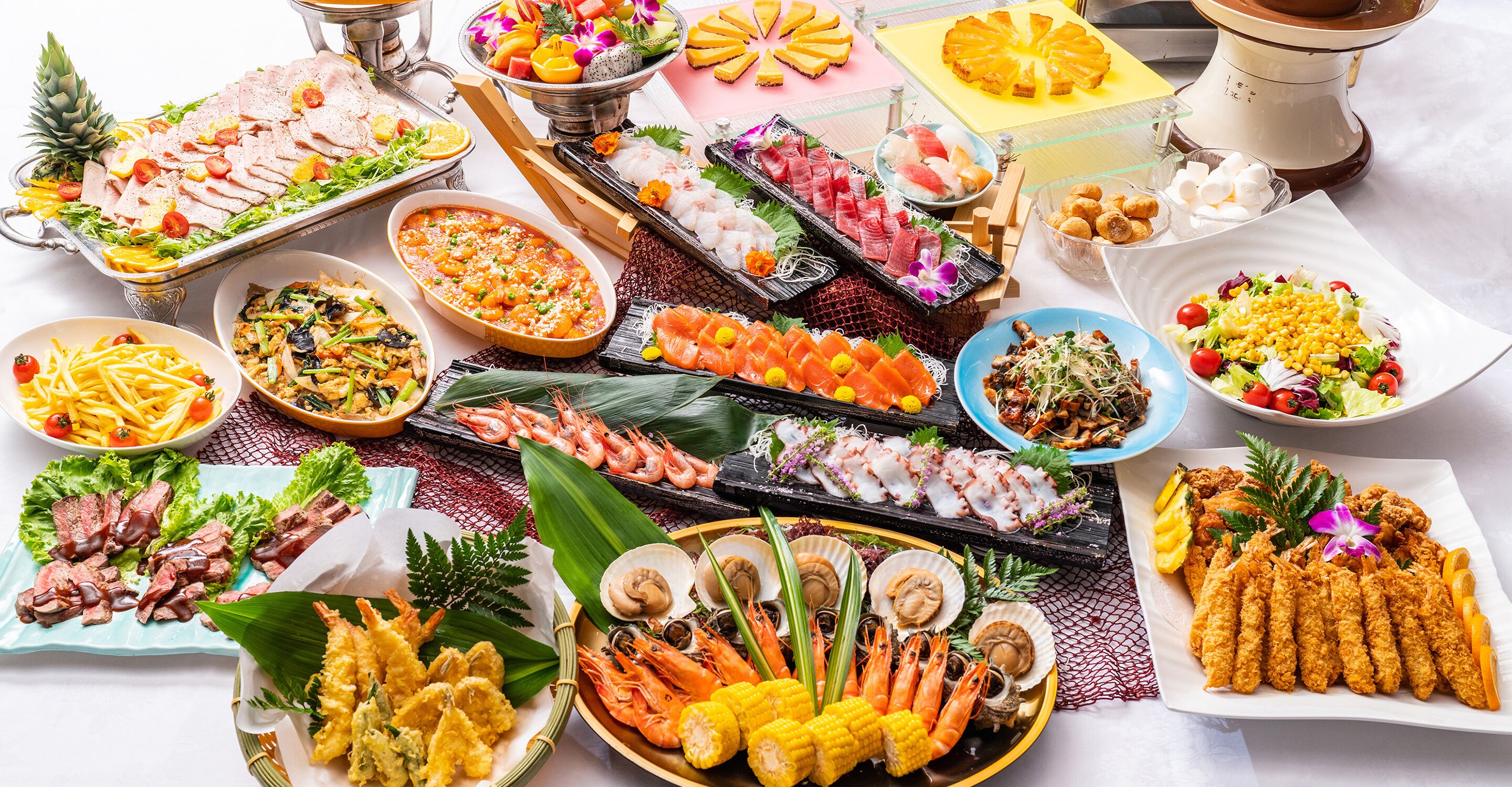A variety of seafood dishes, including shrimp, scallops, and sushi, arranged on a table.