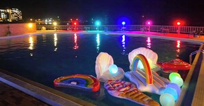 A swimming pool at night with colorful lights and inflatable pool toys. - Mikazuki Sea-Park Hotel Awa Kamogawa (Kamogawa)