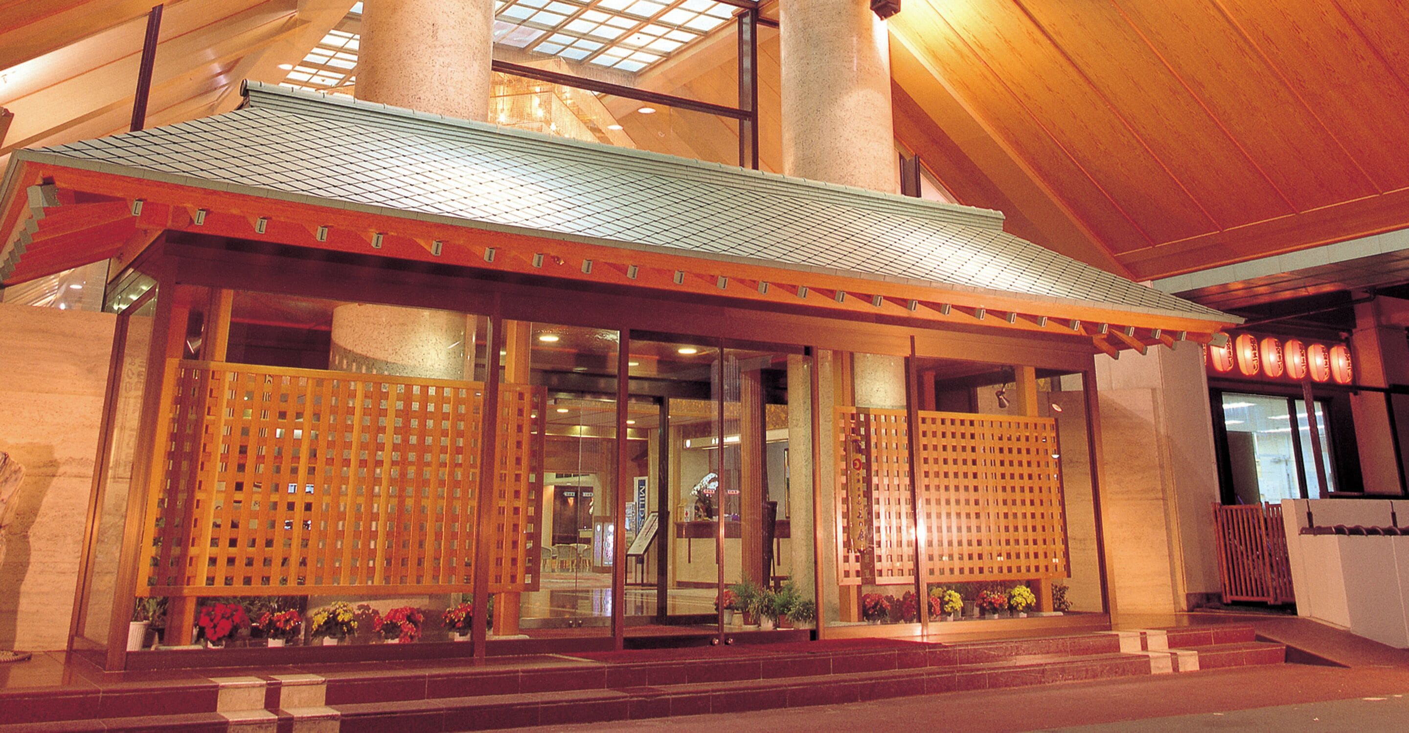 A building with a traditional architectural style, featuring a prominent entrance with a tiled roof and wooden lattice doors.