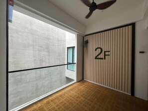 A modern hotel room with a large window, a ceiling fan, and a room number sign. - Miyabi Hotel (Masai)