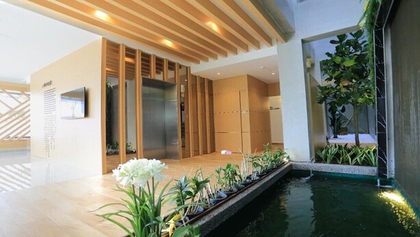 A modern interior with a wooden floor, a small indoor water feature, and potted plants. - Miyabi Hotel (Masai)