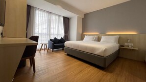 A modern hotel room with a large bed, a desk, a chair, and a sofa. - Miyabi Hotel (Masai)