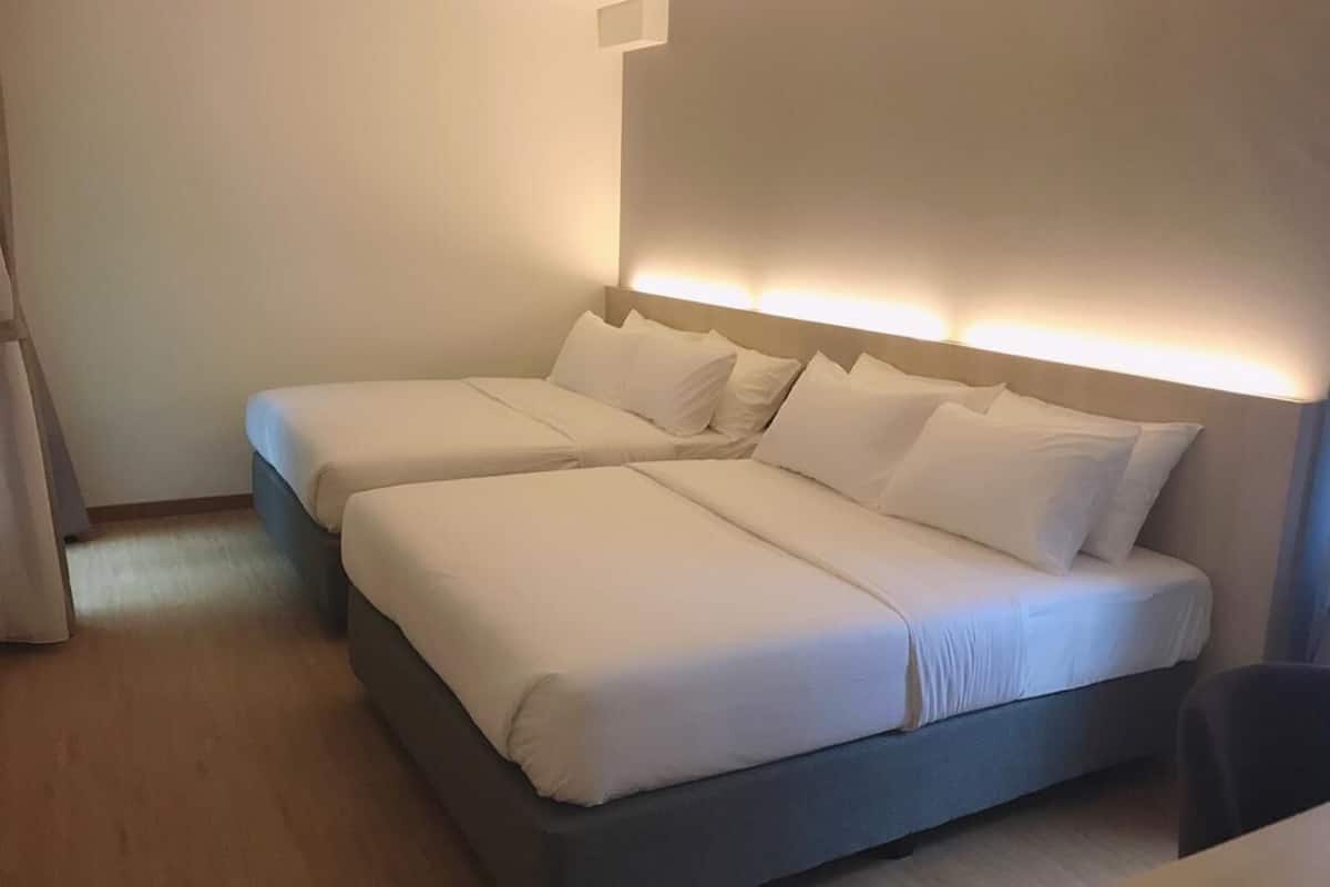 A double bed with a headboard and bedside tables in a hotel room.