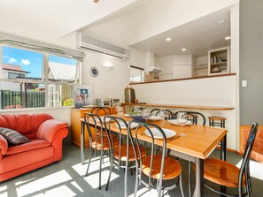 A compact living space with a dining area, a red sofa, and a kitchen area.