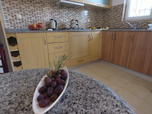 Full-size fridge, stovetop, electric kettle, cookware/dishes/utensils