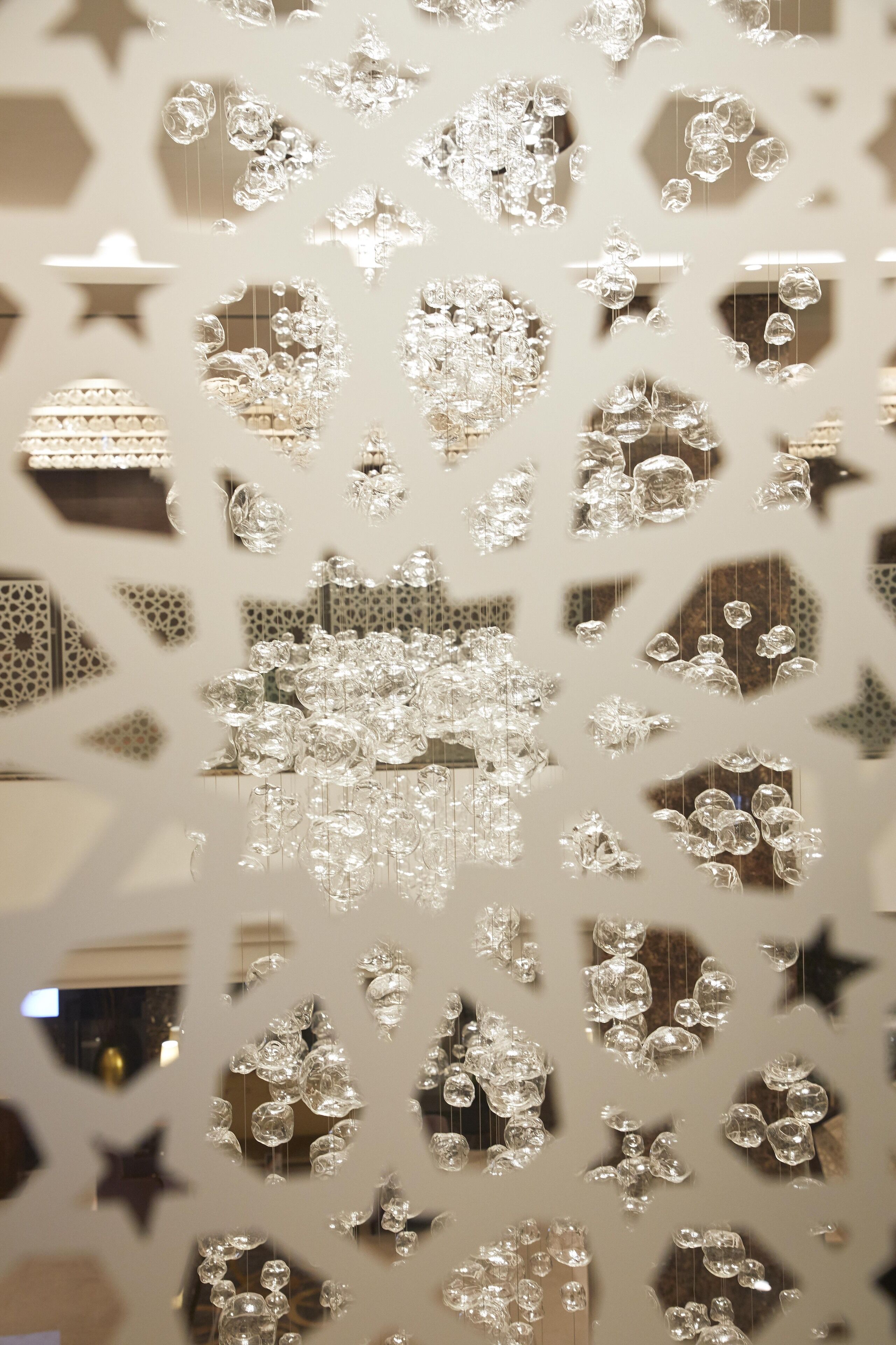 Una instalación decorativa de vidrio con patrones geométricos y formas de estrella.