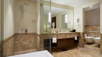 A modern bathroom with a glass-enclosed shower, a large mirror, a bathtub, and a vanity with a sink and mirror.