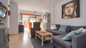 A living room with a sofa, a coffee table, and a painting on the wall.