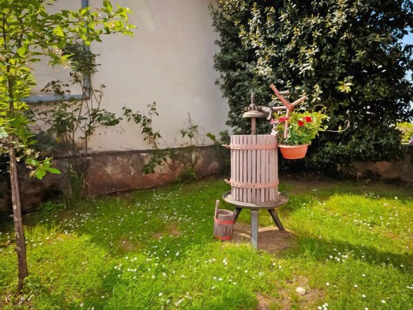 A garden with a vintage-style water feature, surrounded by greenery and a potted plant. - Vacation home Lišera by Interhome (Rovinj/Rovinjsko Selo)