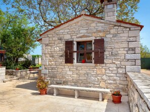 A stone building with a small window and shutters, a bench, and potted plants. - Vacation home Lišera by Interhome (Rovinj/Rovinjsko Selo)