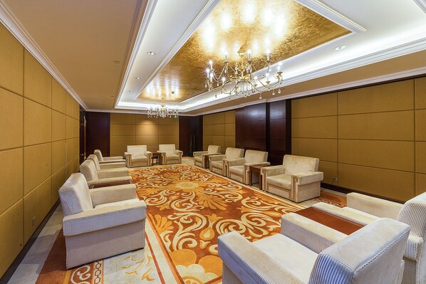 A conference room with a long table, multiple chairs, and a chandelier.