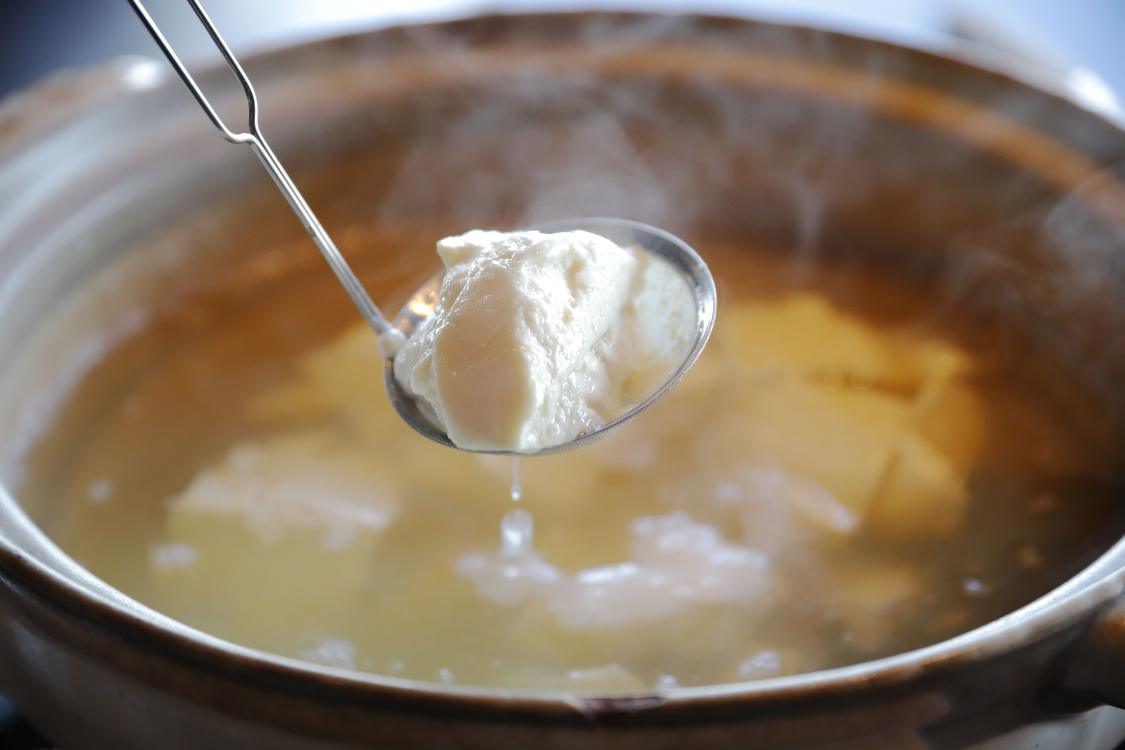 A spoonful of ice cream being lifted from a bowl.