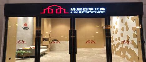 A hotel entrance with a modern design, featuring a logo and signage above the doors.