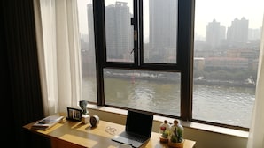 A desk with a laptop, a clock, a calendar, and a plant. - LN Residence Guangzhou Changdi - Free shuttle between hotel and Exhibition Center during Canton Fair (Guangzhou)
