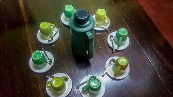 Ein Tisch mit einem zentral platzierten grünen Objekt, umgeben von acht grünen Tassen und Untertassen.