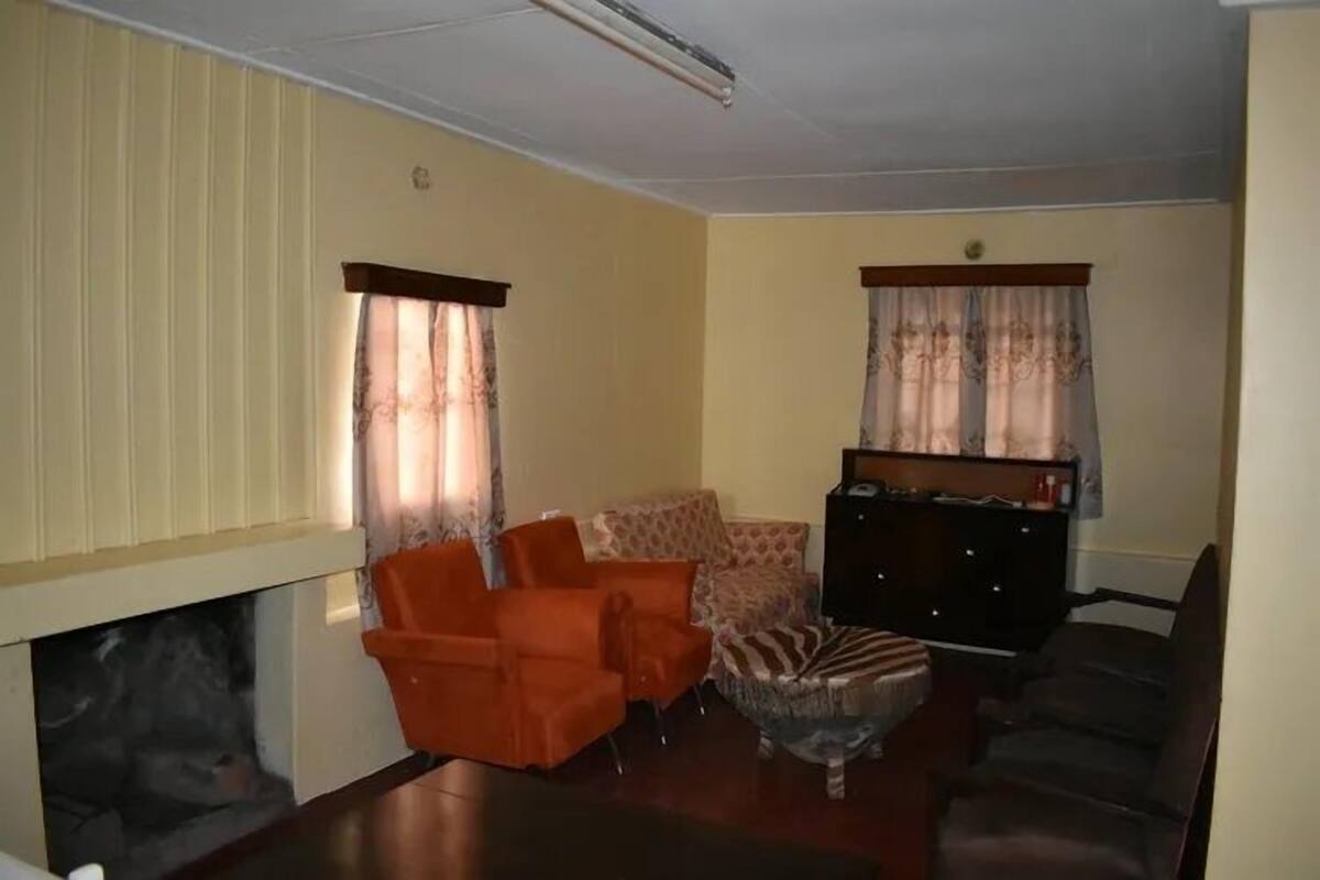 A living room with a fireplace, two sofas, a coffee table, and a television.
