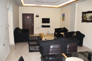 Habitación, 2 habitaciones | Sala de estar | Televisión de pantalla plana de 32 pulgadas con canales por satélite