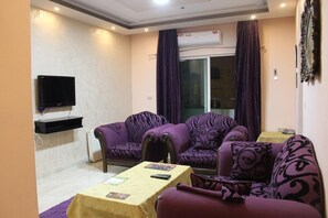 Habitación, 2 habitaciones | Zona de estar | Televisión de pantalla plana de 32 pulgadas con canales por satélite