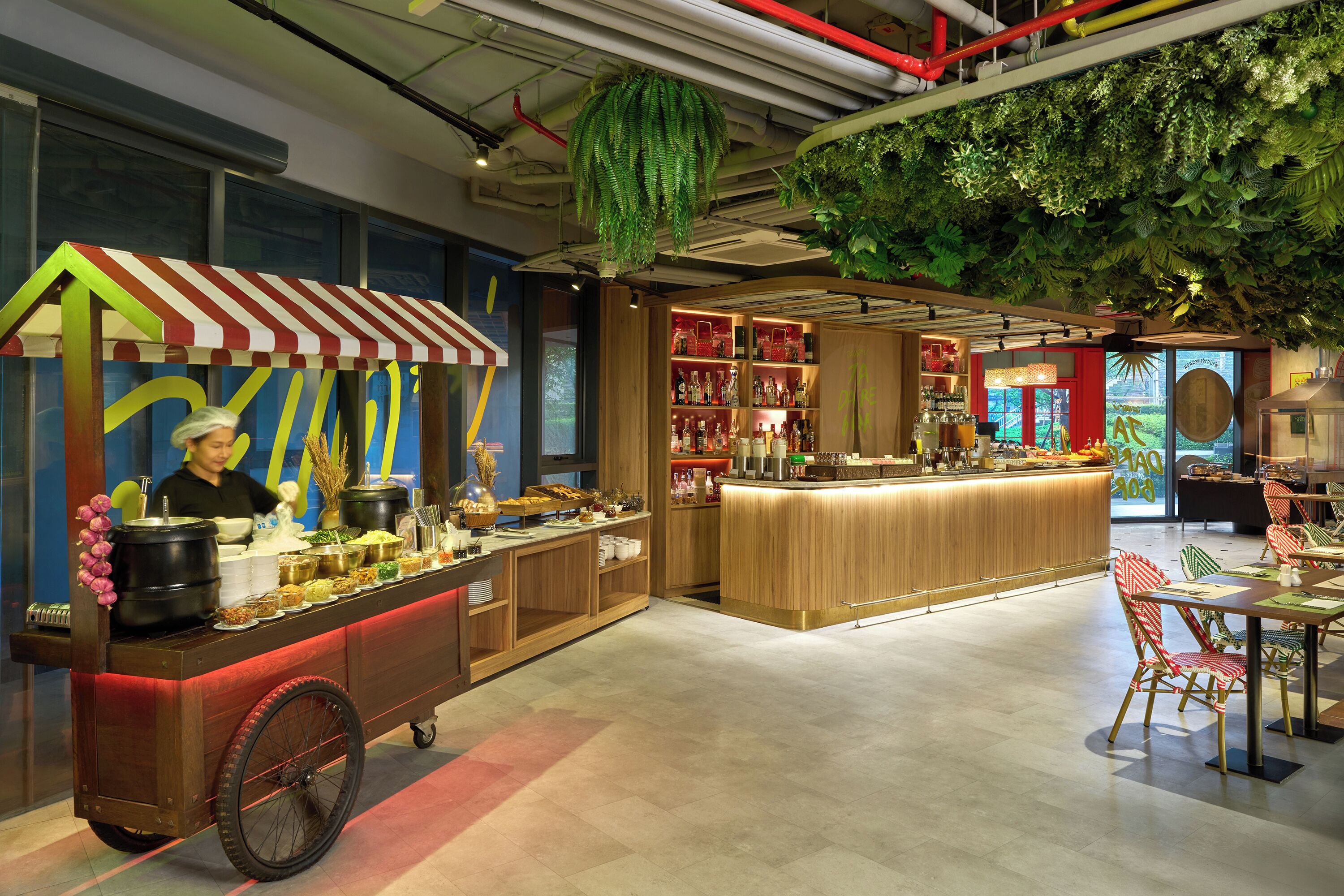 Restaurante com carrinho de comida, área de bar e assentos com vista para o exterior.