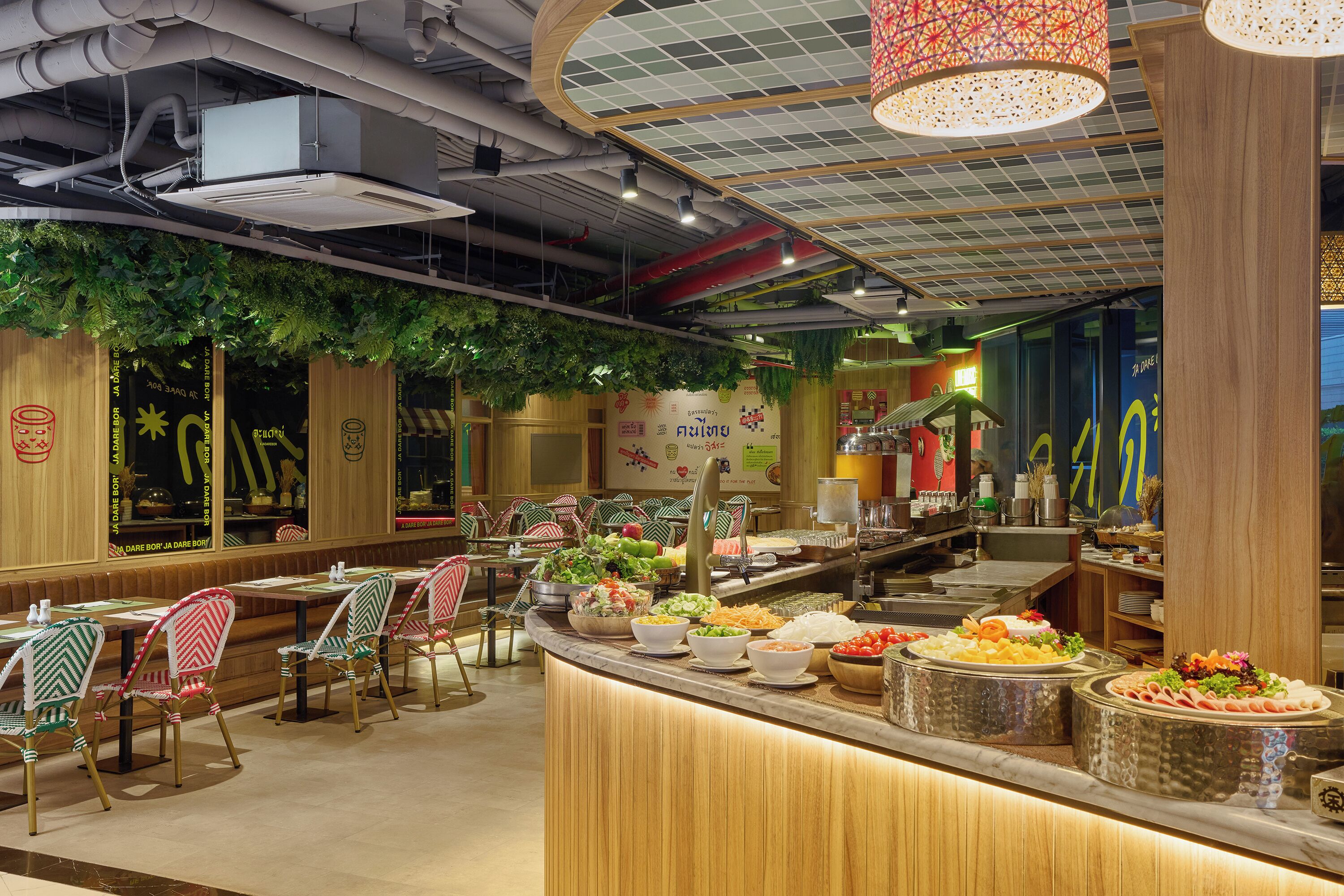 Interior de restaurante con barra de buffet, zona de estar y detalles decorativos en el techo.