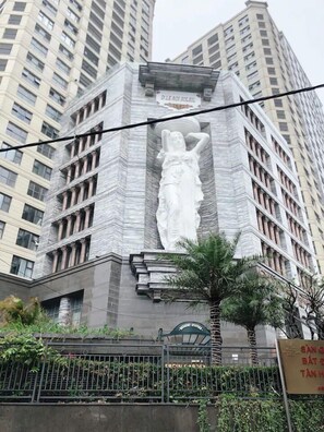 A building with a large white statue of a woman on the facade. - Bayhomes D' Le Roi Soleil Apartment (Hanoi)
