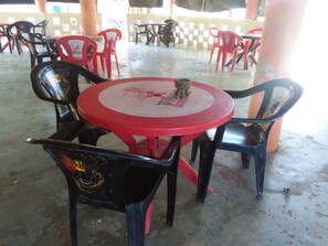 A round red table with a white center surrounded by black and red plastic chairs. - Migingo Half London (Mtwapa)