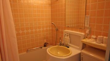 A bathroom with a bathtub, sink, toilet, and a shower curtain.