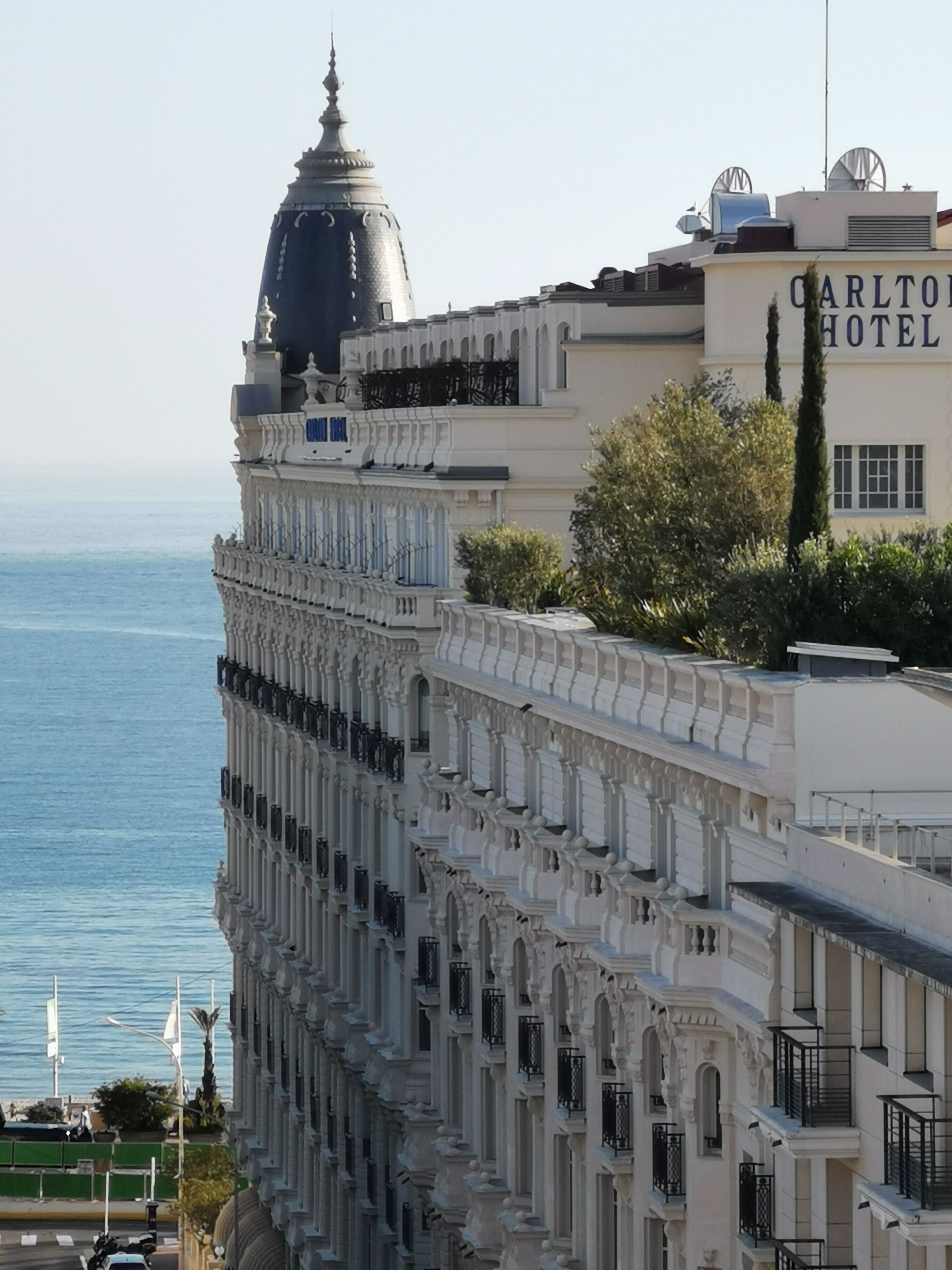 A historic building with ornate architecture, a prominent dome, and a Carlton Hotel sign.