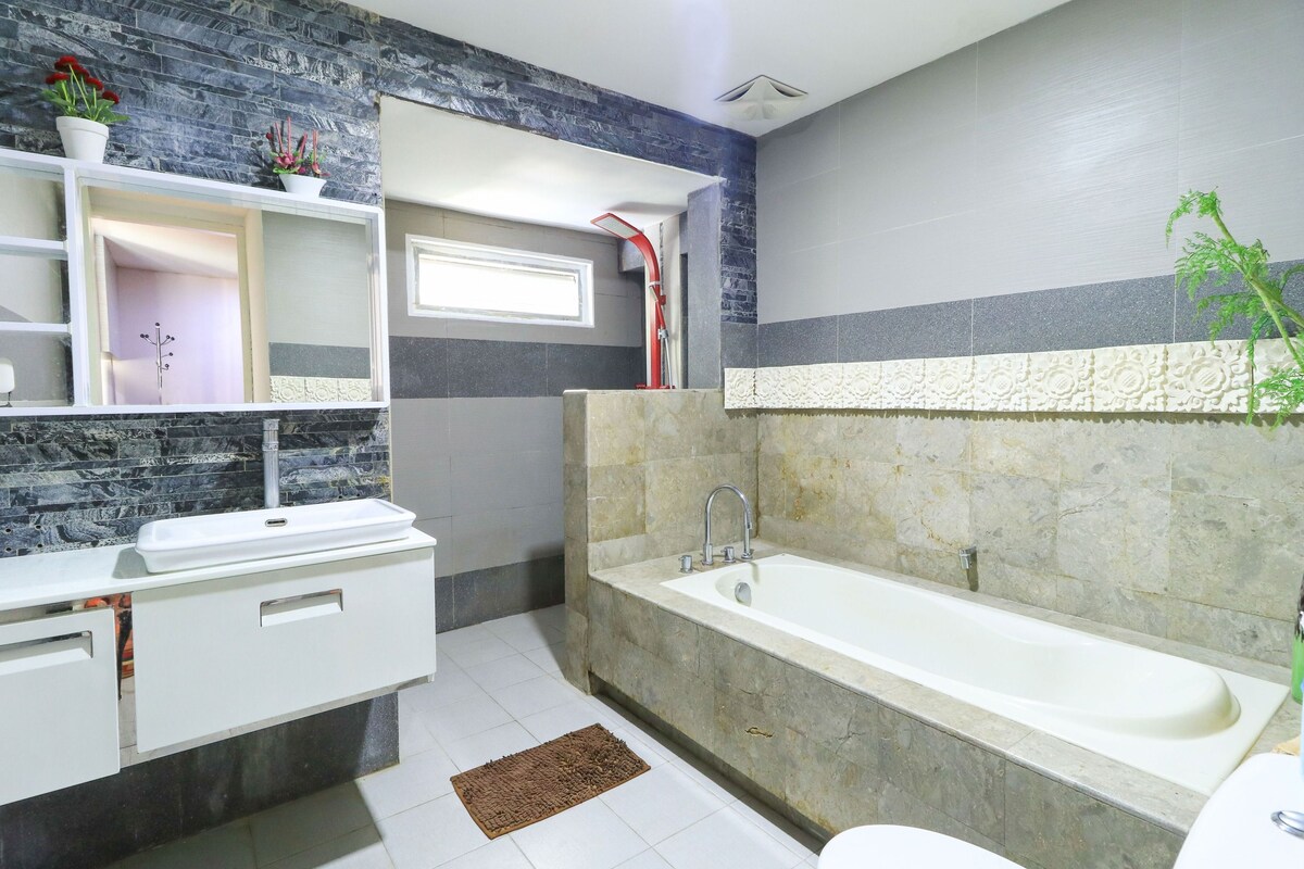 Un baño moderno con lavamanos blanco, bañera y retrete.