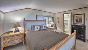 Une chambre à coucher avec un lit en bois, des tables de chevet, une commode, une coiffeuse et un miroir.