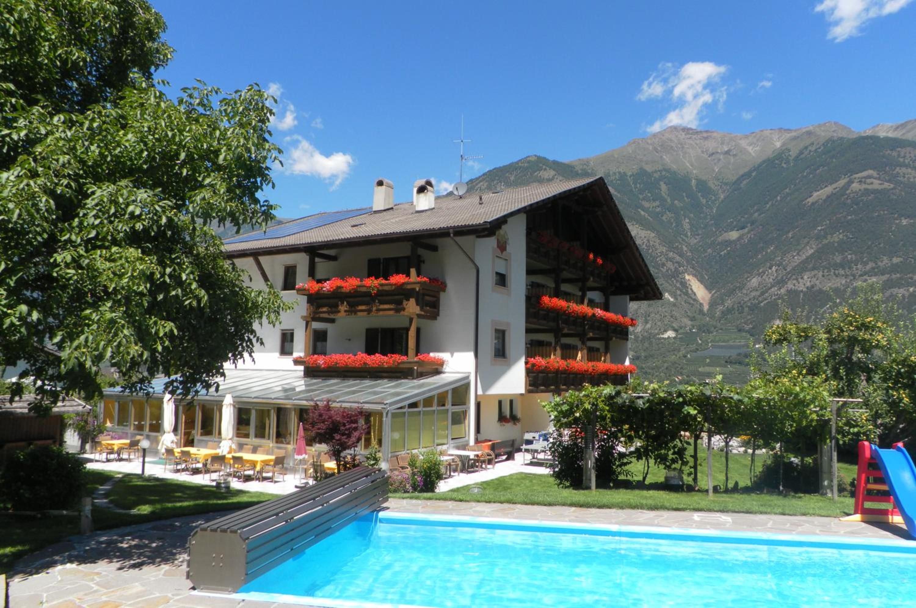 Un hôtel doté d’une piscine, d’un espace extérieur aménagé et offrant une vue sur les montagnes.
