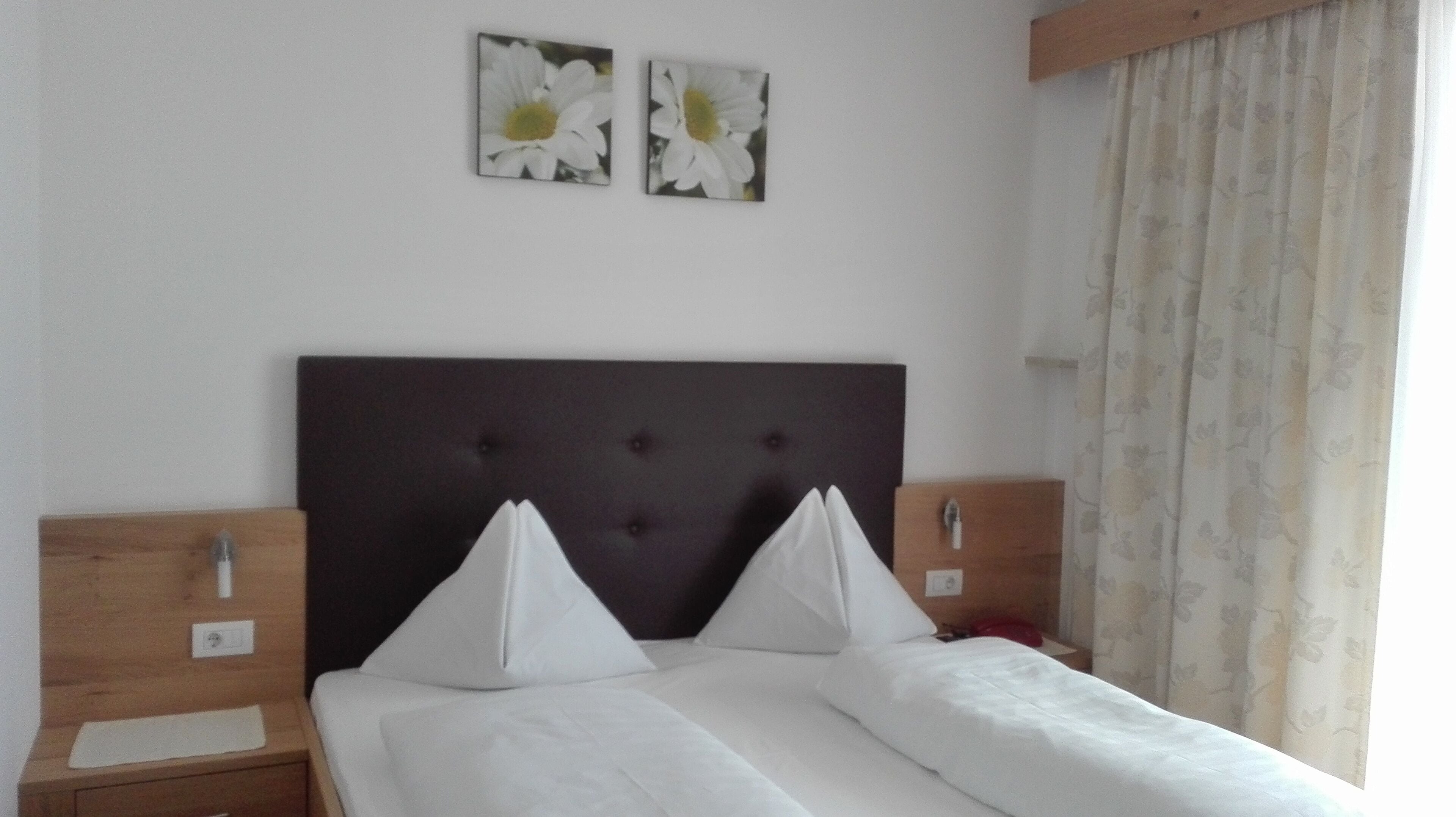 A hotel room with a large bed, two nightstands, and a headboard with tufting.