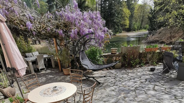 Une terrasse avec un sol en pierre, des meubles d’extérieur et des plantes en pot.