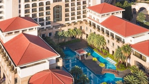 An aerial view of a hotel with multiple buildings, a central swimming pool, and surrounding greenery. - Mingcheng Hotel Fuzhou (Fuzhou)