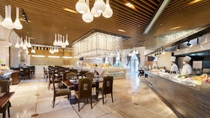 A spacious restaurant with high ceilings, modern pendant lighting, and a central kitchen area. - Mingcheng Hotel Fuzhou (Fuzhou)
