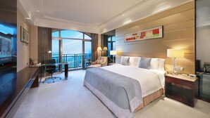A hotel room with a large bed, a desk with a computer, a chair, and a view of the city. - Mingcheng Hotel Fuzhou (Fuzhou)
