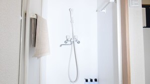 A small, white, enclosed shower area with a handheld showerhead, a towel rack, and a light fixture. - Oval Tokyo Ikesan 201 (Tokyo)