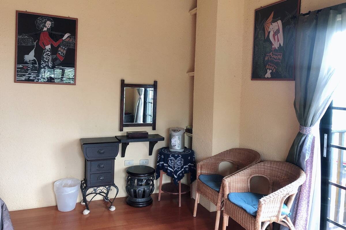 Ein Zimmer mit Schreibtisch, Stuhl und zwei Bildern an der Wand.