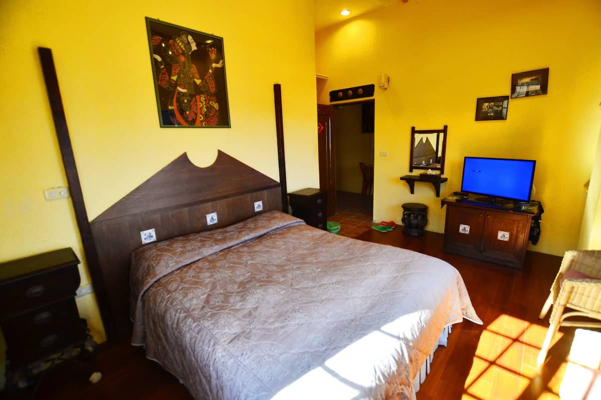 Ein Schlafzimmer mit einem großen Bett, einem Fernseher und einem Holzkapfen.